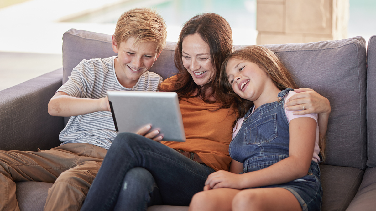Mother and two kids smile at iPad