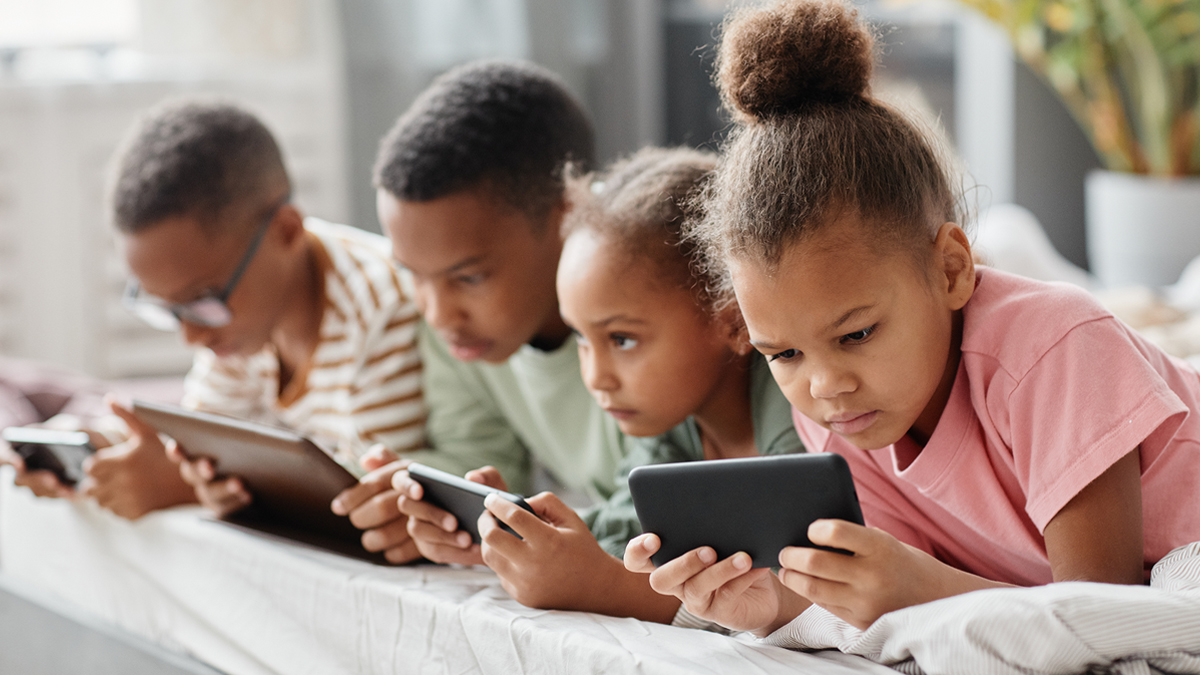 Four kids in a row on devices