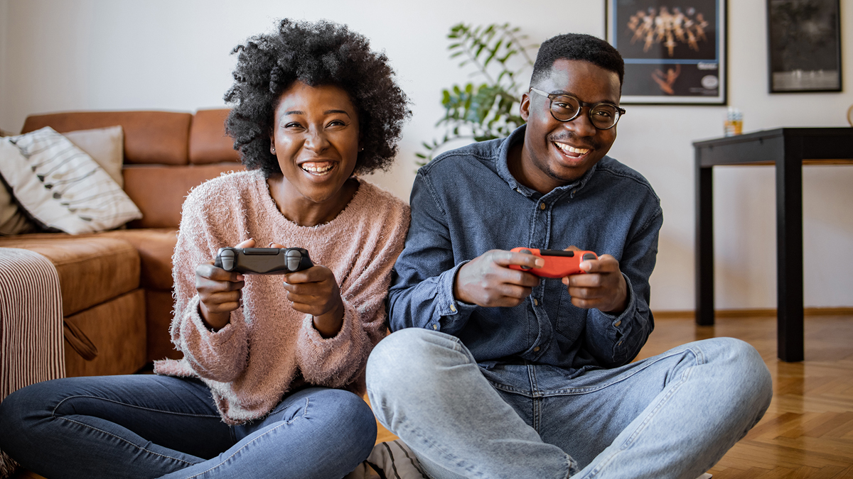 A woman and a man playing video games in living room