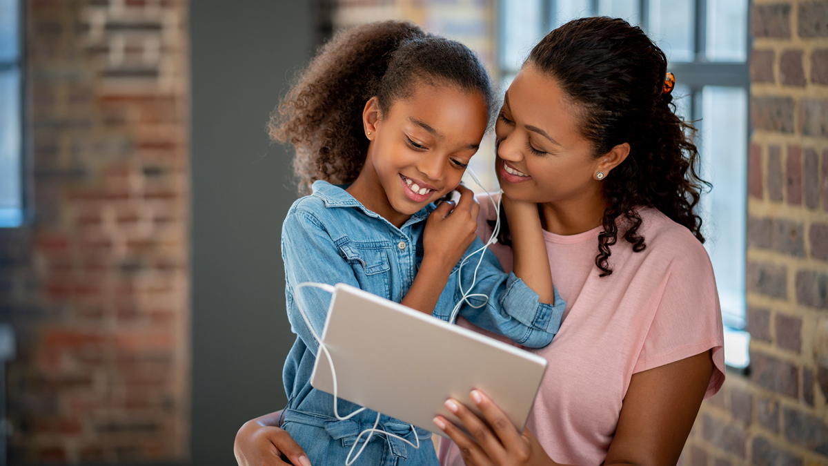 Mother and daughter listening with earbuds together