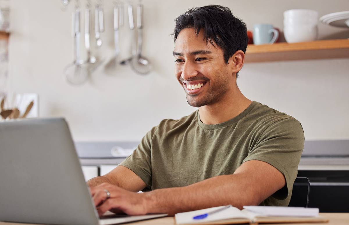 Man working on laptop in his kitchen