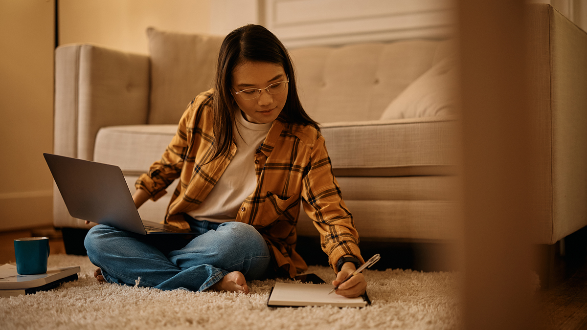 Student doing homework on living room floor