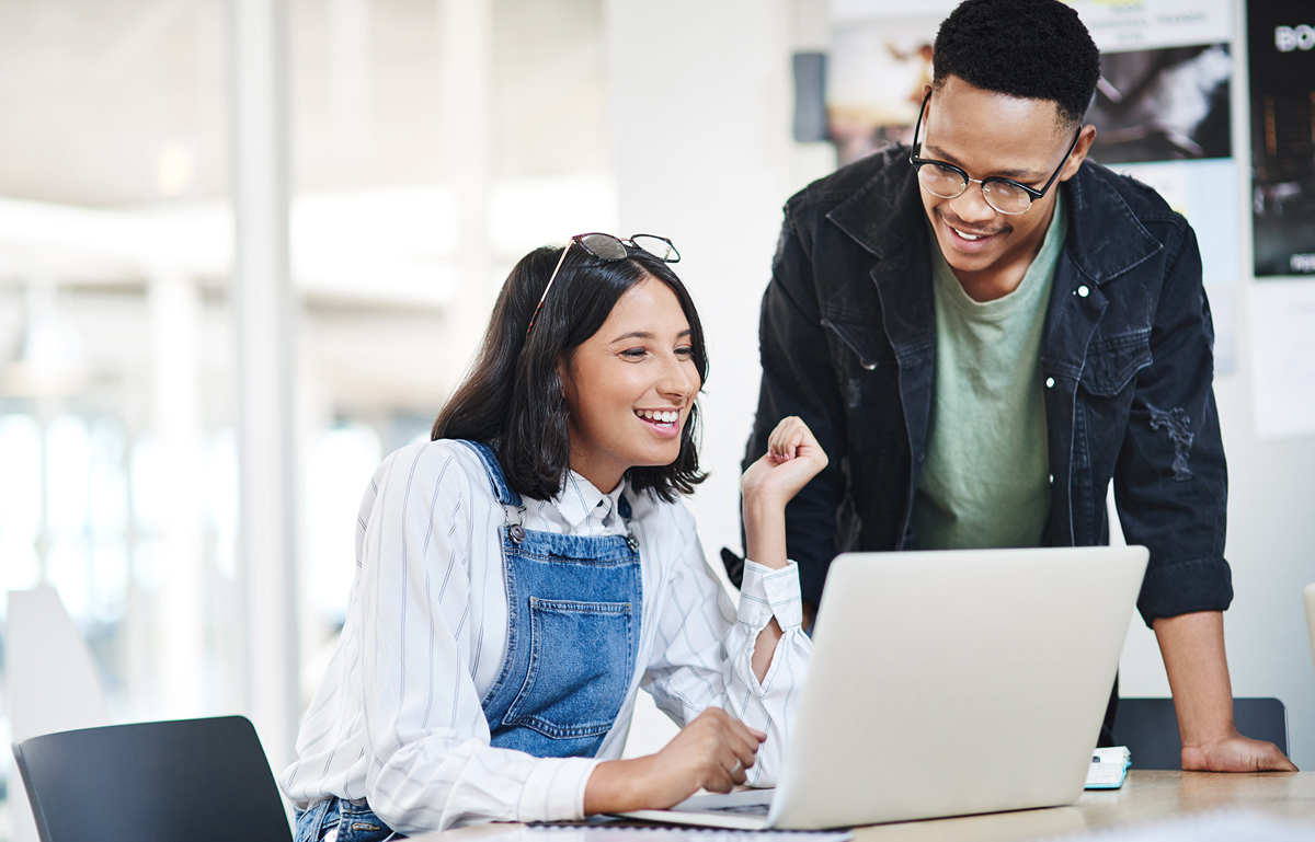 Man and woman working on laptop in office together