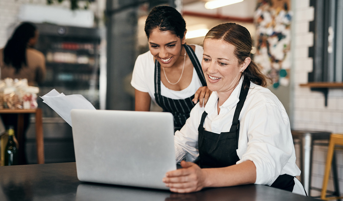 Coffee shop owners happy while looking at laptop