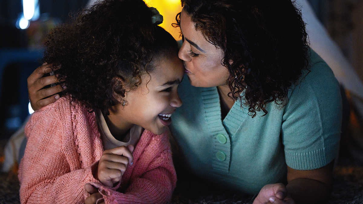 Mother kissing daughter on the forehead