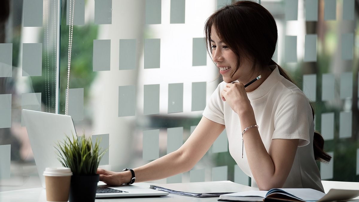 Woman smiling at computer in office