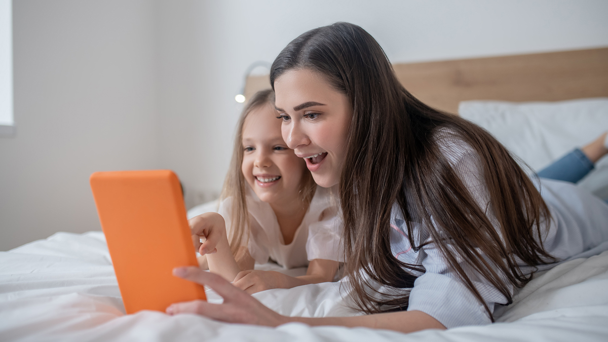 Mother and daughter on digital tablet together