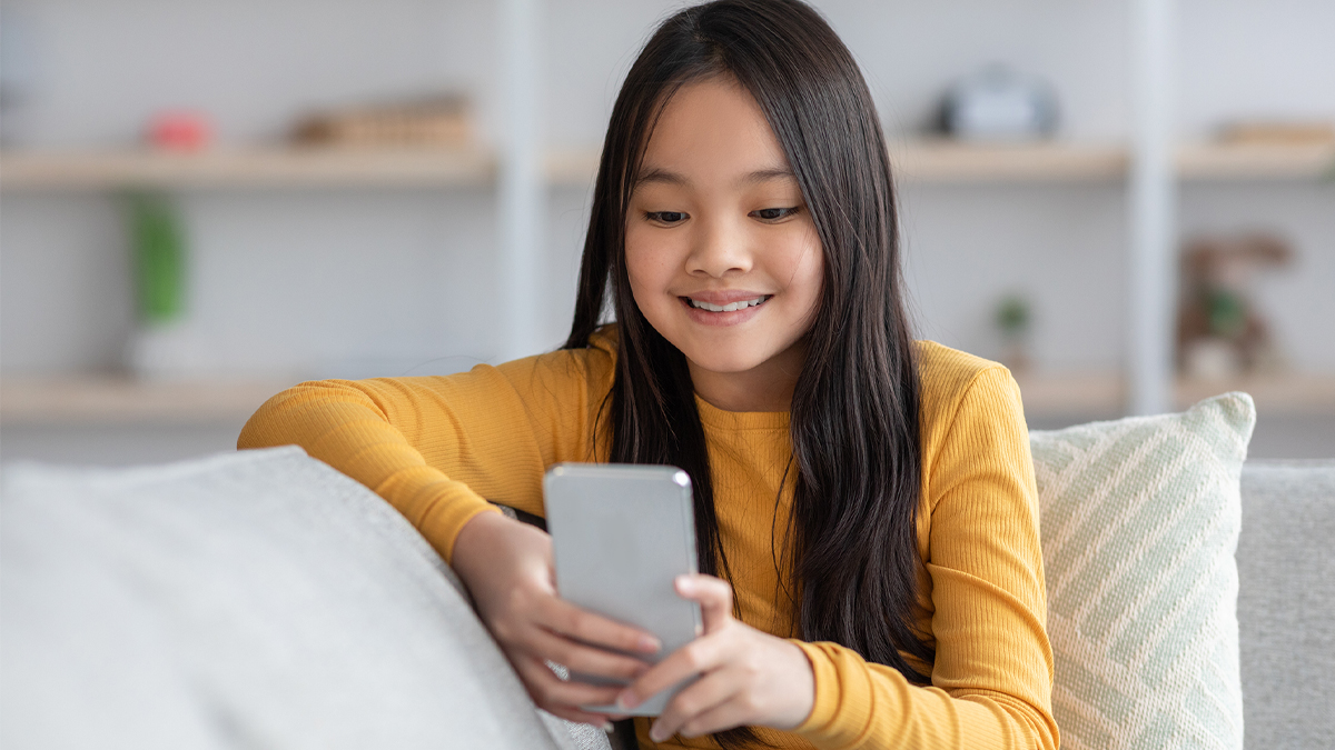 Young girl smiling at phone screen