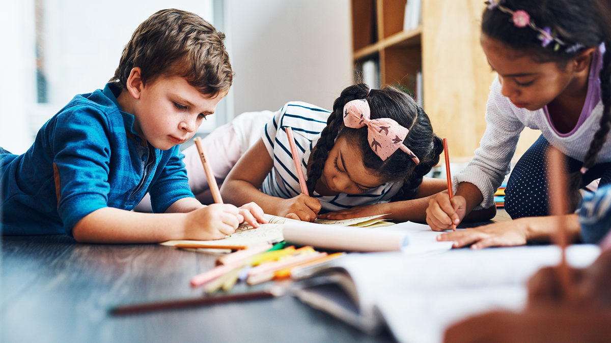 Kids coloring together on hardwood floor