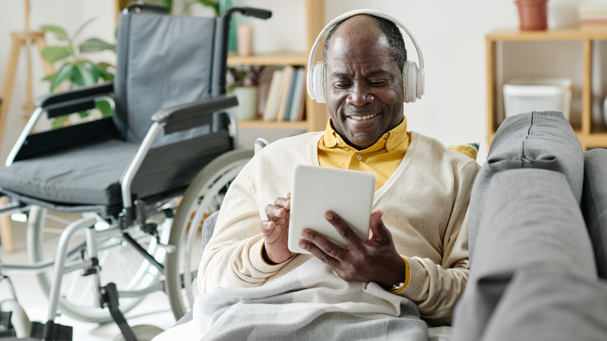 Senior man with headphones on, scrolling through music options