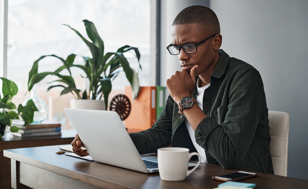 Person contemplating computer screen in home office