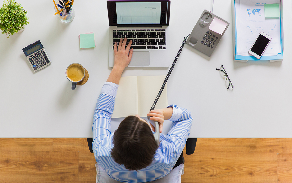 Woman on landline phone call while working from home