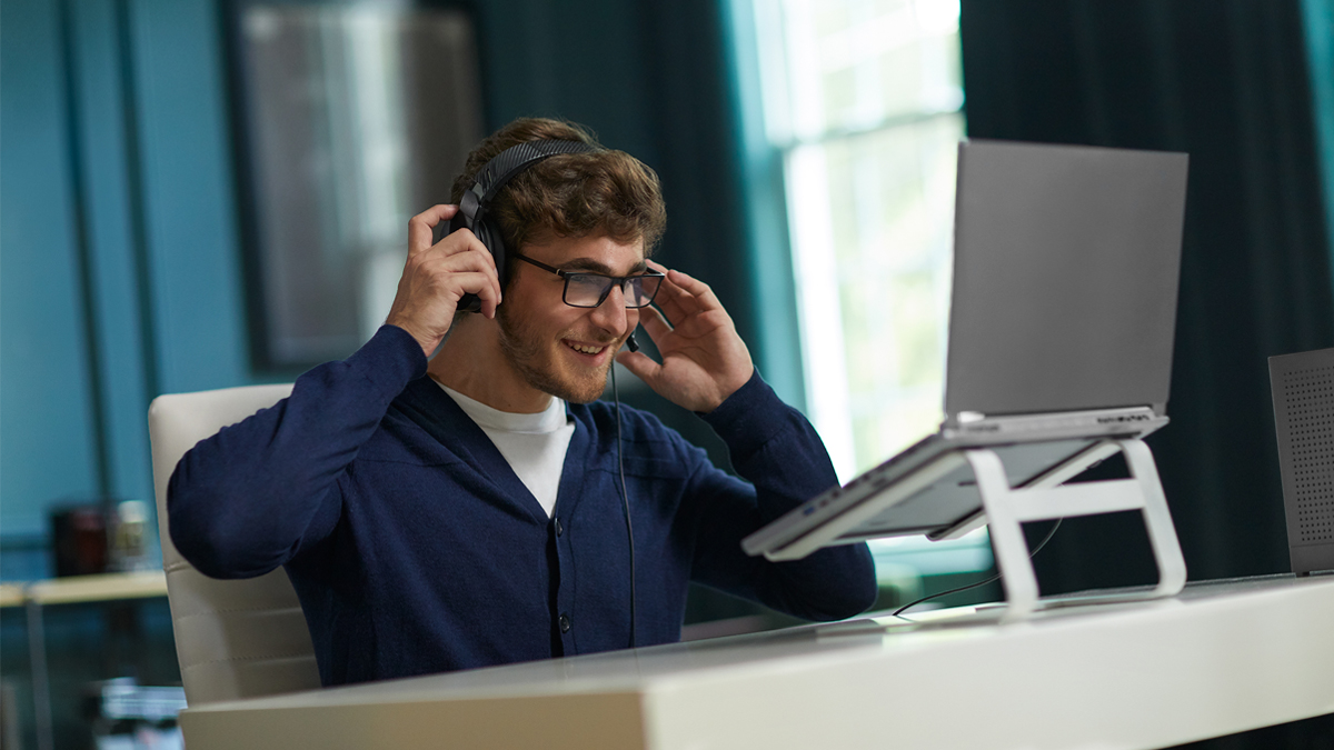 Man with headset on computer with Kosciusko Connect router in the corner