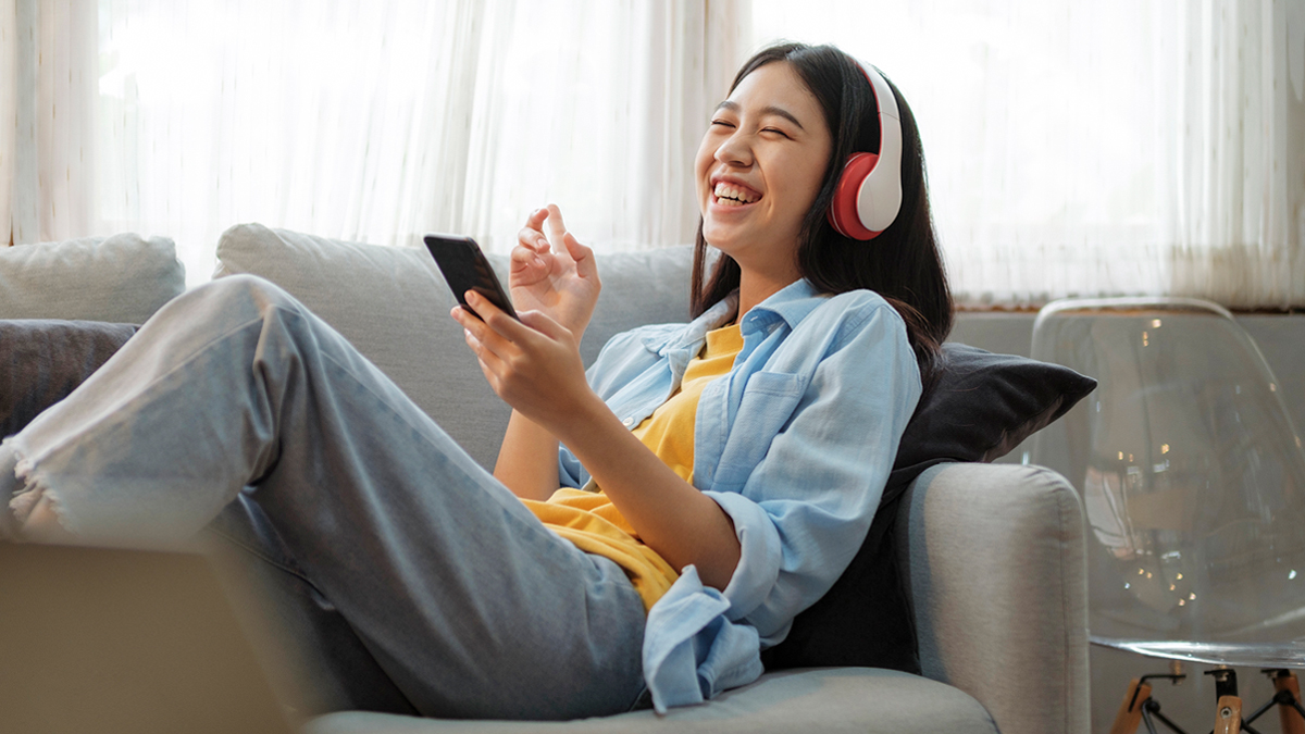 Woman with headphones listening to music at home